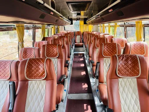 Maharaja luxury interior with white upholstered headrests, wood trim, red carpet aisle