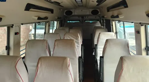 Spacious 26 seater Tempo Traveller luxury cabin interior with clean seats and curtains